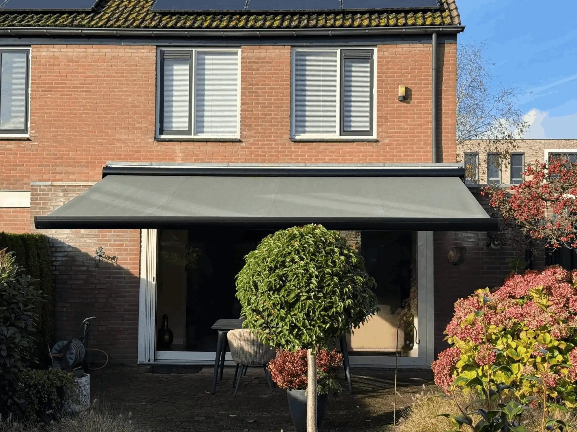 Dit is de foto die we hebben genomen van de achtertuin nadat het scherm er hangt